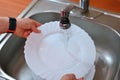 Hand washing dishes. Hand with sponge and sink in kitchen washing dirty dishes - plate Royalty Free Stock Photo