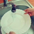 Hand washing dishes. Hand with sponge and sink in kitchen washing dirty dishes - plate Royalty Free Stock Photo