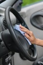 Hand washing wheel of car with rag