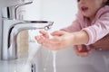 Hand, water and cleaning with a girl and her mother washing her hands under a tap for hygiene and sanitation during Royalty Free Stock Photo