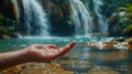 A hand with water droplets, waterfall background. Royalty Free Stock Photo