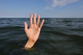 hand in the sea of a person who is drowning and seeks help