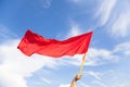 Hand waving a red flag with blue sky background Royalty Free Stock Photo