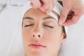 Hand waxing beautiful woman's eyebrow Royalty Free Stock Photo