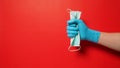 Hand wear glove and holding face Mask on red background