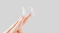 Hand Wear White Sock of People on Grey Studio Light. Side View of Beautiful Young Woman Wearing Bright Cotton Fabric Socks on Gray