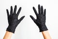 A hand wearing black glove with spread fingers on a white background, close up