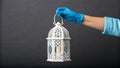 A hand wearing a blue glove holding a white lantern with copyspace for Ramadan kareem Royalty Free Stock Photo
