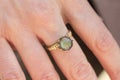 Hand wearing brass ring with shiny labradorite gemstone