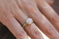 hand wearing brass ring with shiny moonstone gemstone
