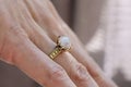 hand wearing brass ring with shiny moonstone gemstone