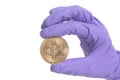 Hand wearing Purple Glove holds Bitcoin Crypto Currency.Mining concept. Royalty Free Stock Photo