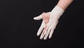 Hand Wearing torn latex glove or torn rubber gloves on black background Royalty Free Stock Photo