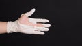 Hand Wearing torn latex glove or torn rubber gloves on black background Royalty Free Stock Photo