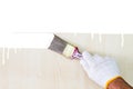 Hand wearing white glove holding old grunge paintbrush and painting on wooden wall Royalty Free Stock Photo
