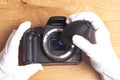 Hand wearing white gloves cleaning camera with air dust blower Royalty Free Stock Photo