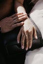 A hand of wedding couple touch each other. Hands newlyweds with wedding rings close up. Bridal hands with rings on black leather Royalty Free Stock Photo