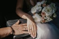 A hand of wedding couple touch each other. Hands newlyweds with wedding rings close up. Bridal hands with rings on black leather Royalty Free Stock Photo