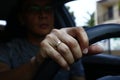 Hand with wedding ring of an Asian man inside a car holding the steering wheel Royalty Free Stock Photo