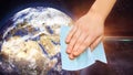 Hand with wet wipe cleaning planet on quarantine from virus
