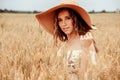 Hand wheat field woman. Happy young woman in sun hat in summer wheat field at sunset. Nature, summer holidays Royalty Free Stock Photo