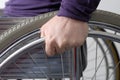 Hand on wheel of wheelchair close-up