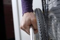 Hand on wheel of wheelchair close-up