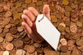 The hand which is sticking out of heap of coins with sales tag.Copy space Royalty Free Stock Photo