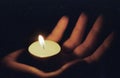 Hand in which there is a lighted candle