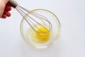 Hand whipping egg white with a metal whisk in a glass bowl Royalty Free Stock Photo