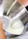 Hand whipping egg whites into a foam in a steel bowl Royalty Free Stock Photo