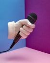 A hand in a white glove holds a microphone. Podcast. Hand gesture