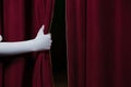 Hand in a white glove pulling curtain away Royalty Free Stock Photo