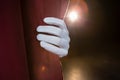 Hand in a white glove pulling curtain away Royalty Free Stock Photo