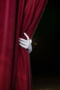 Hand in a white glove pulling curtain away Royalty Free Stock Photo