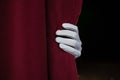 Hand in a white glove pulling curtain away Royalty Free Stock Photo