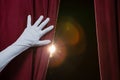 Hand in a white glove pulling curtain away Royalty Free Stock Photo