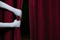 Hand in a white glove pulling curtain away Royalty Free Stock Photo