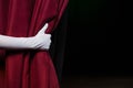 Hand in a white glove pulling curtain away Royalty Free Stock Photo