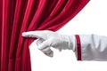 hand in a white glove pulling red curtain away, hand open red velvet curtain to stage Royalty Free Stock Photo