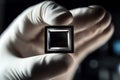 hand in white gloves holding an advanced third-generation microchip with a black, rectangular shape, set against a clean Royalty Free Stock Photo