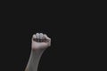 Hand in white medical glove is clenched into a fist. gesturing hand in protective glove on a black background Royalty Free Stock Photo