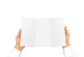 Hand in white shirt sleeve holding blank offset paper in the han