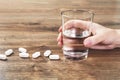 Hand with white tablets on wooden table. Medicine Royalty Free Stock Photo