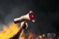 Hand wields megaphone, projecting fervent message in the heart of protest action