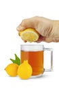 The hand will squeeze the lemon juice into a cup of tea Royalty Free Stock Photo