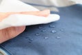 hand wipes drops of water from a cloth. Water drops on waterproof textile material. short depth of field. Waterproof Royalty Free Stock Photo