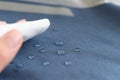 hand wipes drops of water from a cloth. Water drops on waterproof textile material. short depth of field. Waterproof Royalty Free Stock Photo