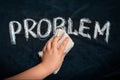 Hand wiping off chalk word PROBLEM on black chalkboard using rag. Remove problem issue solution concept Royalty Free Stock Photo
