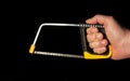 Hand wizard holding a hacksaw with clipping path on black isolated background